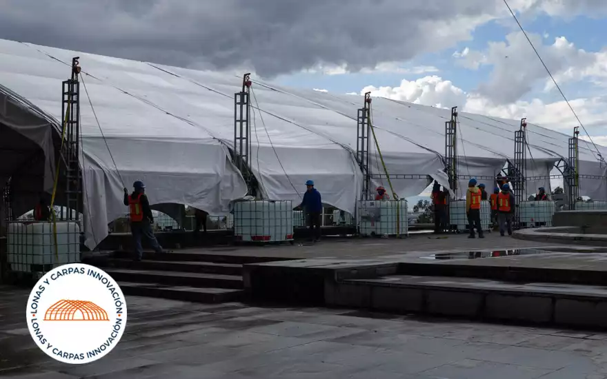 Vista panorámica del montaje de carpas con la ciudad de fondo