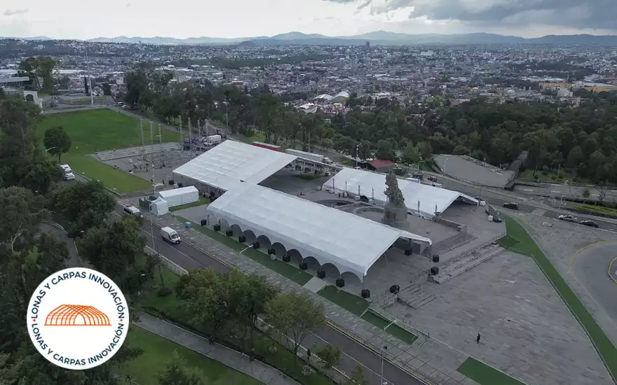 Vista panorámica del montaje de carpas con la ciudad de fondo
